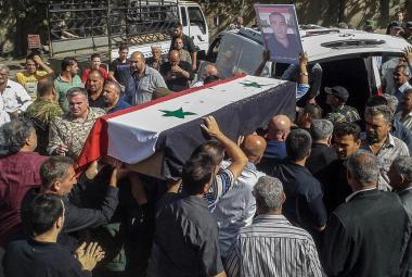 Syrian mourners carry coffins of victims of an ISIS attack on Sweida, 26 July 2018. SANA
