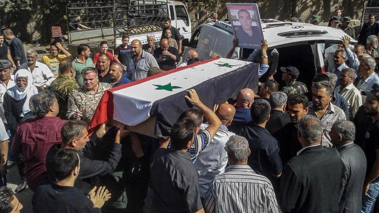 Syrian mourners carry coffins of victims of an ISIS attack on Sweida, 26 July 2018. SANA